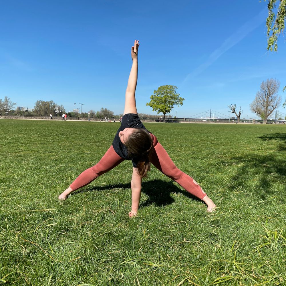 Bianca macht eine Yoga Pose auf der Wiese